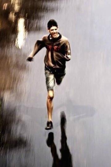 在雨中独肢奔跑的男孩图片